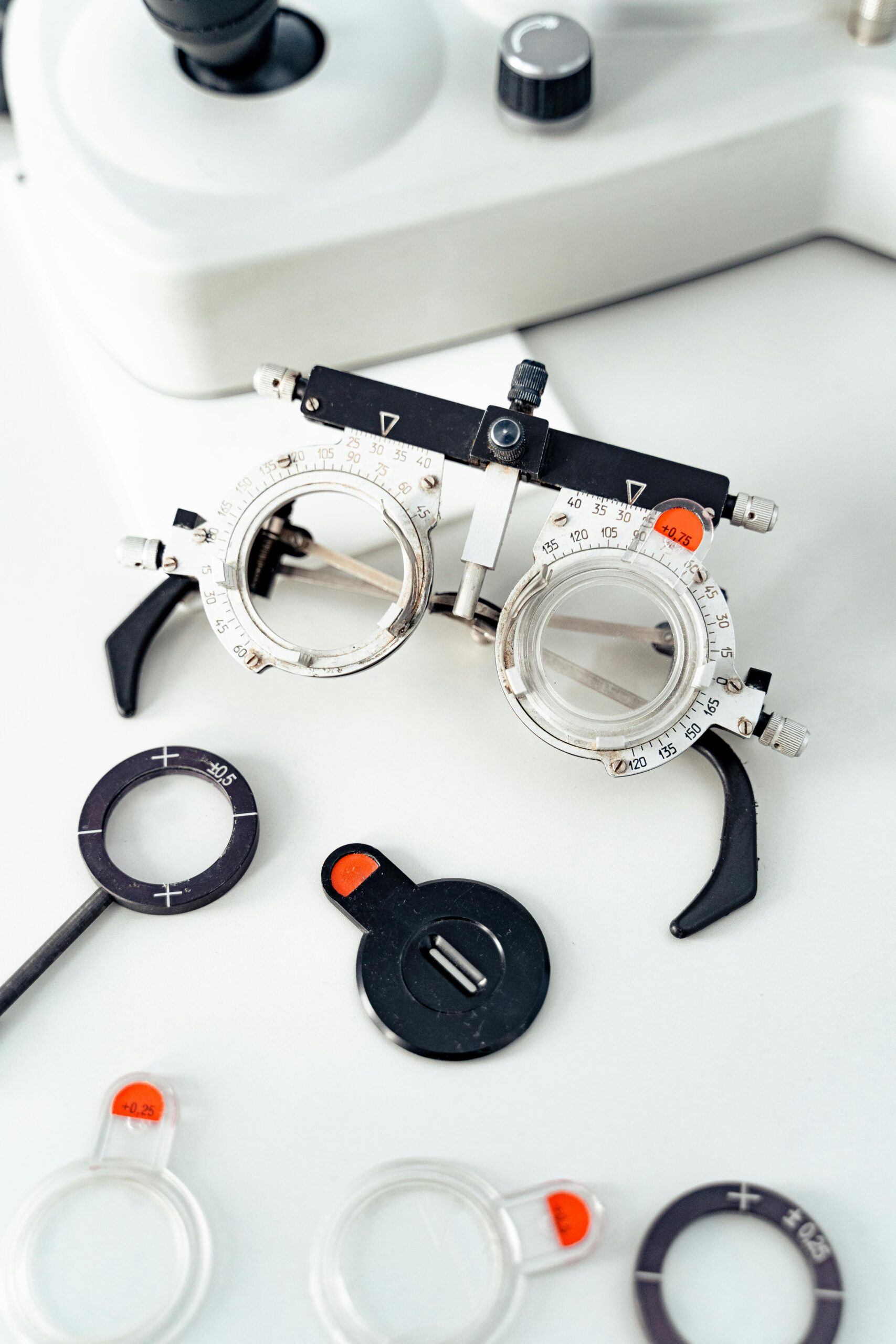 Close-up of optometry trial frame and lenses on white surface.